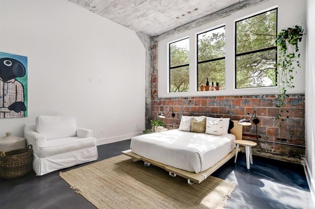 bedroom with concrete floors and brick wall