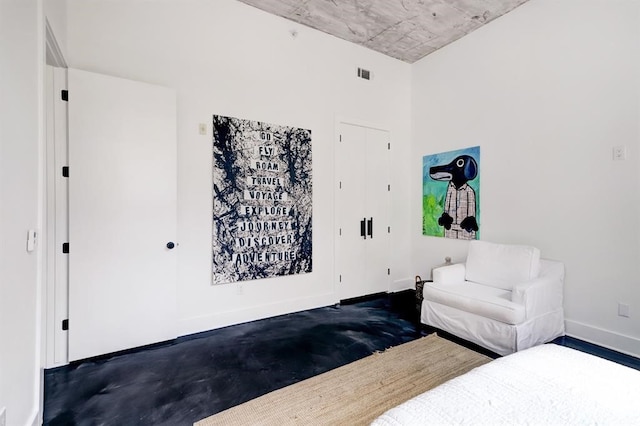 bedroom with baseboards, visible vents, and concrete flooring