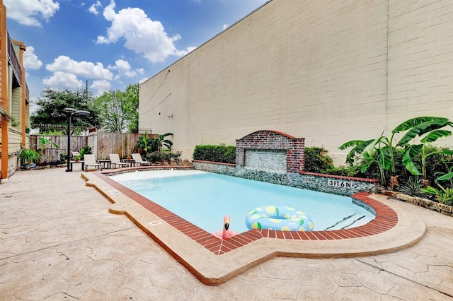 view of pool featuring fence and a patio