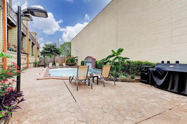 view of patio featuring a fenced backyard, a fenced in pool, and area for grilling