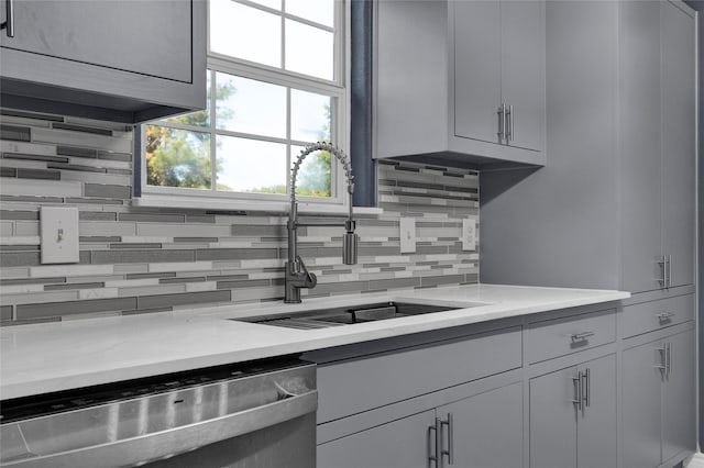 kitchen with dishwasher, tasteful backsplash, gray cabinetry, and sink