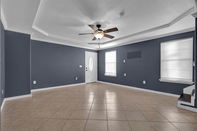 foyer featuring ornamental molding, a textured ceiling, and a tray ceiling