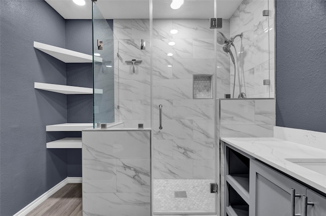 bathroom with vanity, an enclosed shower, and wood-type flooring