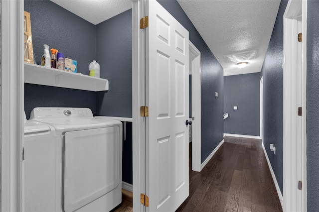 clothes washing area featuring a textured ceiling, washer and dryer, and dark hardwood / wood-style floors