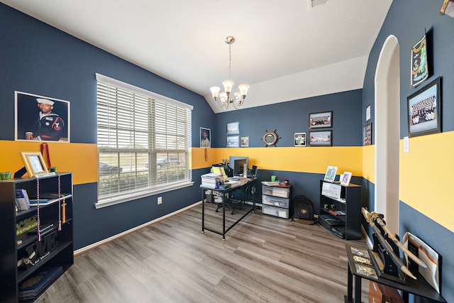 office featuring an inviting chandelier, wood-type flooring, and vaulted ceiling