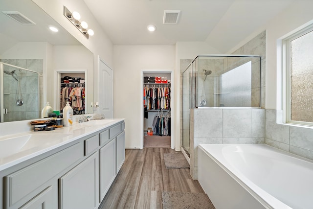 bathroom featuring shower with separate bathtub, hardwood / wood-style flooring, and vanity