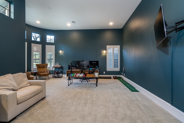 home office featuring a towering ceiling and carpet floors