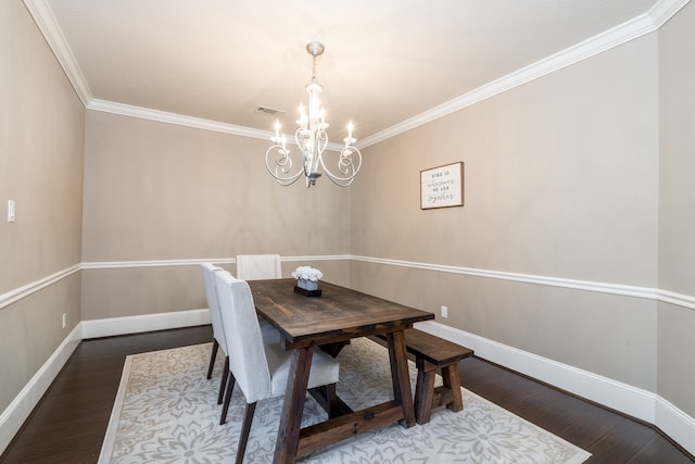 dining room with dark hardwood / wood-style flooring, ornamental molding, and a chandelier