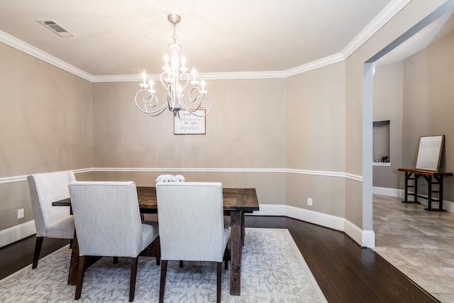 dining room with wood-type flooring, crown molding, and a chandelier