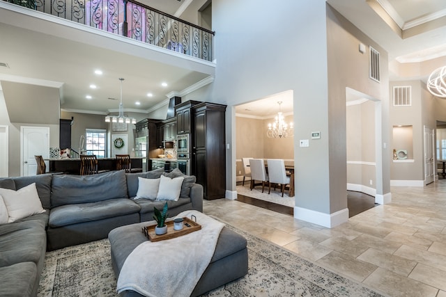 living room with a towering ceiling, crown molding, and a chandelier