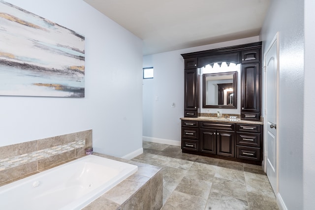 bathroom featuring tiled bath and vanity