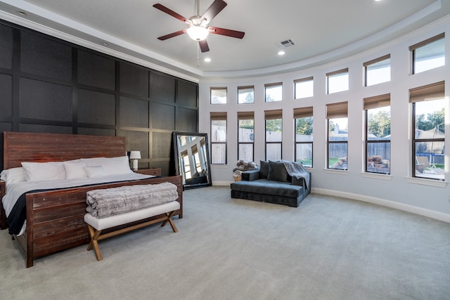 bedroom featuring ceiling fan, light carpet, and a high ceiling