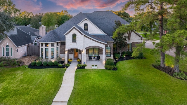 french country style house with a lawn