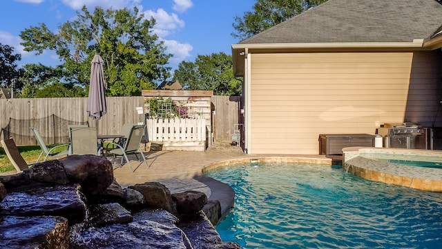 view of swimming pool featuring an in ground hot tub, a patio, and a grill