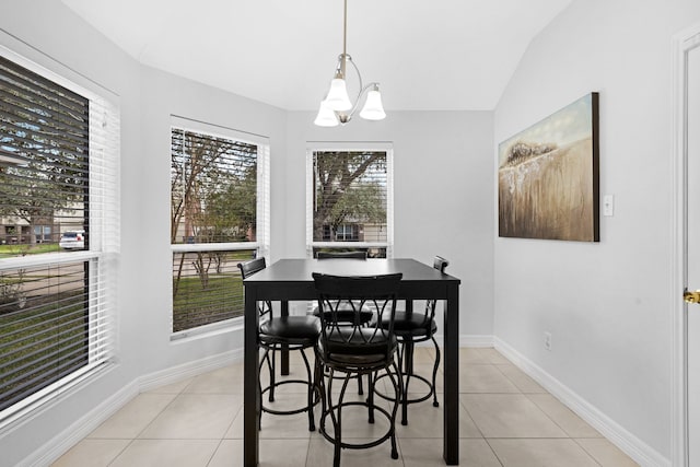 tiled dining area featuring lofted ceiling and an inviting chandelier