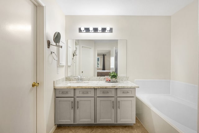 bathroom with a bathtub, vanity, and tile patterned floors