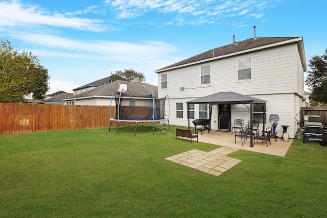 rear view of house with a trampoline, a lawn, a patio area, and a gazebo