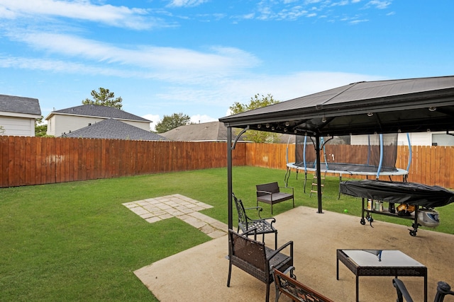 view of yard featuring a trampoline, a patio, and a gazebo