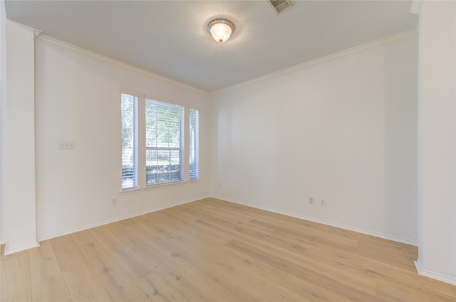 spare room with light hardwood / wood-style floors and crown molding