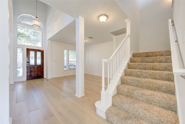 foyer featuring hardwood / wood-style floors, a high ceiling, and a chandelier