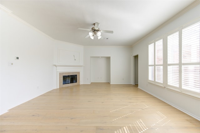 unfurnished living room featuring ornamental molding, light hardwood / wood-style floors, ceiling fan, and a tile fireplace