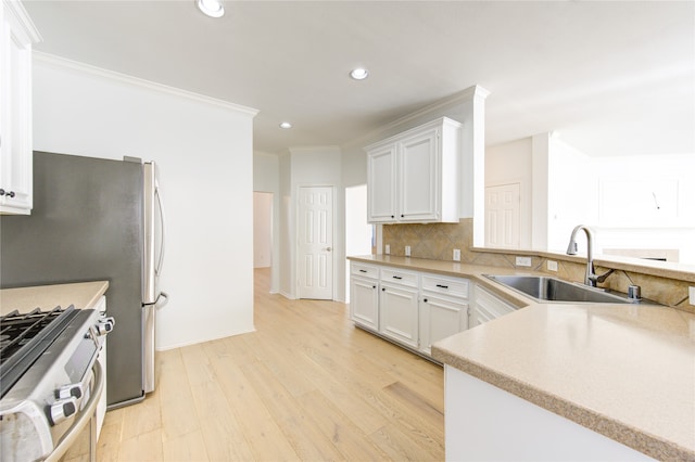 kitchen with white cabinets, stainless steel range, light hardwood / wood-style flooring, and sink