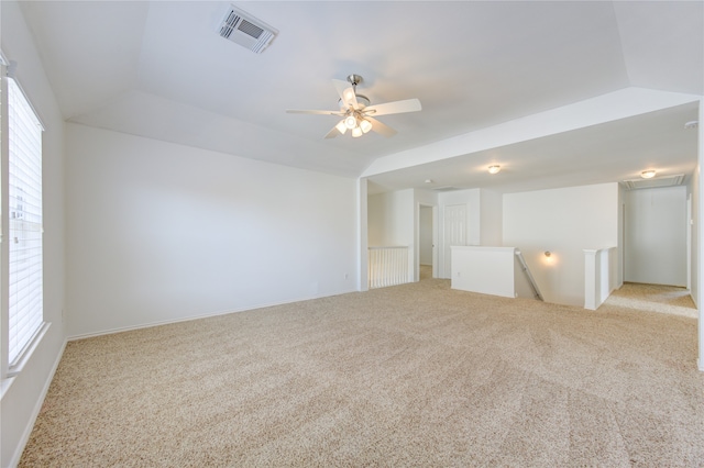 carpeted spare room with ceiling fan and vaulted ceiling