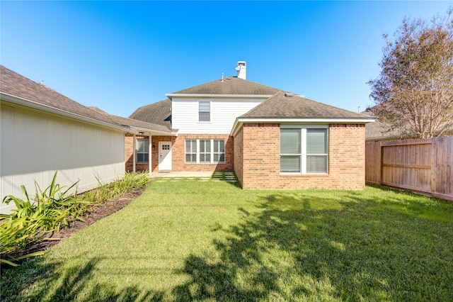 rear view of house featuring a yard