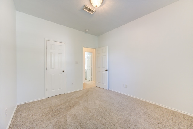 spare room featuring light colored carpet