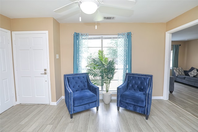 living area featuring light wood-type flooring and ceiling fan