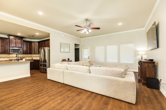 living room with ceiling fan, dark hardwood / wood-style floors, sink, and crown molding