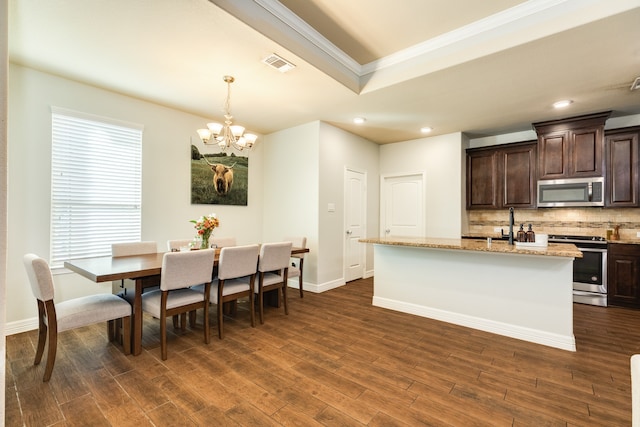 dining room featuring ornamental molding, dark hardwood / wood-style flooring, and a chandelier