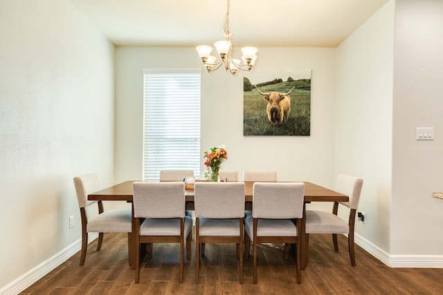 dining room with dark wood-type flooring and an inviting chandelier