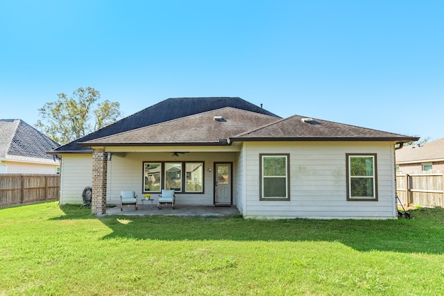 back of house featuring a lawn, ceiling fan, and a patio