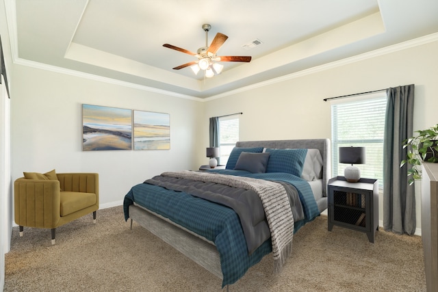 bedroom with ornamental molding, light colored carpet, ceiling fan, and a raised ceiling