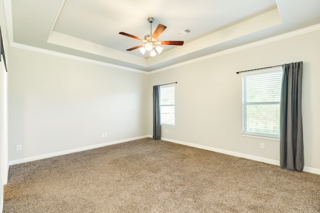 carpeted empty room featuring ceiling fan, a tray ceiling, and ornamental molding