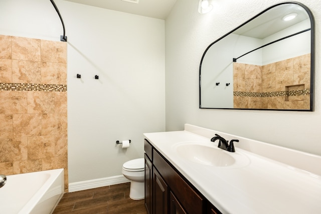 full bathroom with hardwood / wood-style floors, vanity, toilet, and tiled shower / bath