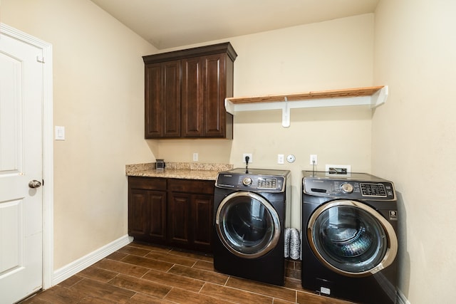 clothes washing area featuring dark wood-type flooring, cabinets, and washing machine and clothes dryer