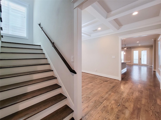 stairway featuring coffered ceiling, wood-type flooring, french doors, and beamed ceiling