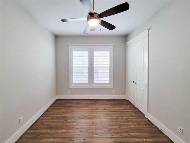 empty room featuring ceiling fan and dark hardwood / wood-style flooring