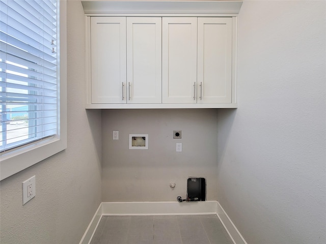 clothes washing area with hookup for a washing machine, gas dryer hookup, electric dryer hookup, and cabinets