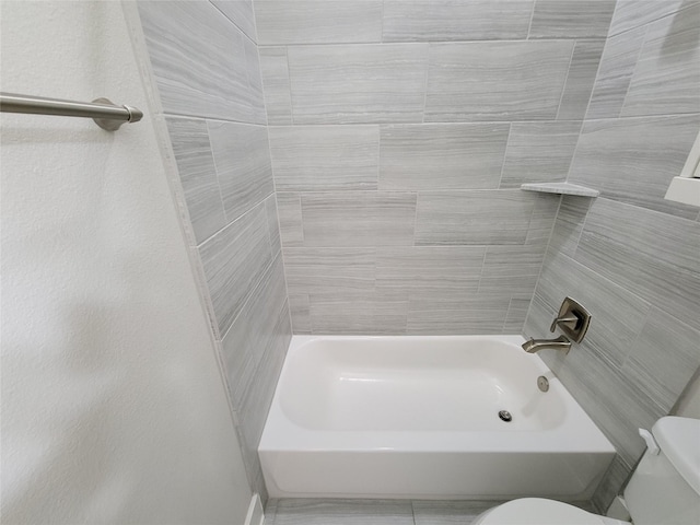 bathroom with tiled shower / bath and toilet