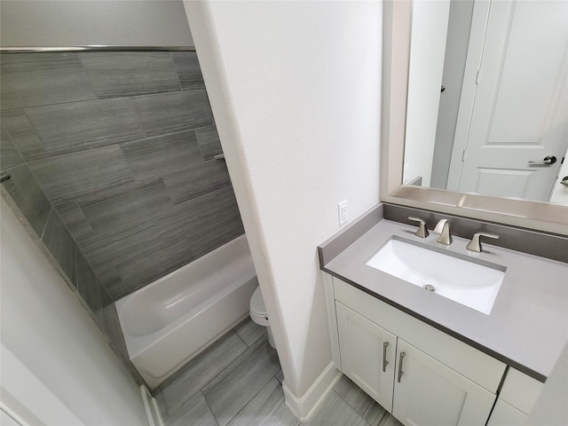 bathroom with tiled shower, vanity, and toilet