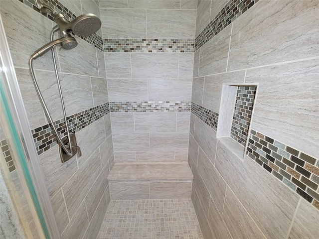 bathroom with ceiling fan and tiled shower