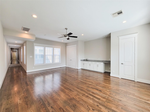 unfurnished living room with hardwood / wood-style flooring and ceiling fan