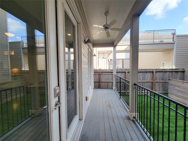 wooden terrace with a lawn and ceiling fan