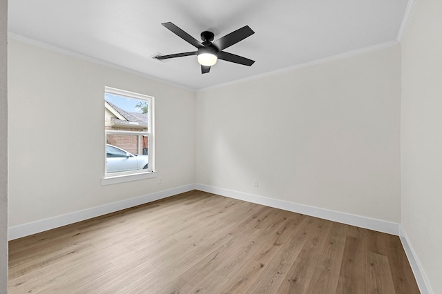 empty room featuring ceiling fan, light wood-type flooring, and ornamental molding