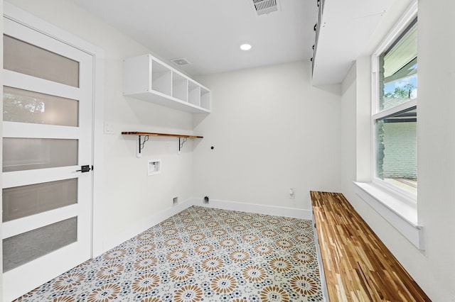 clothes washing area featuring light hardwood / wood-style flooring, electric dryer hookup, and hookup for a washing machine