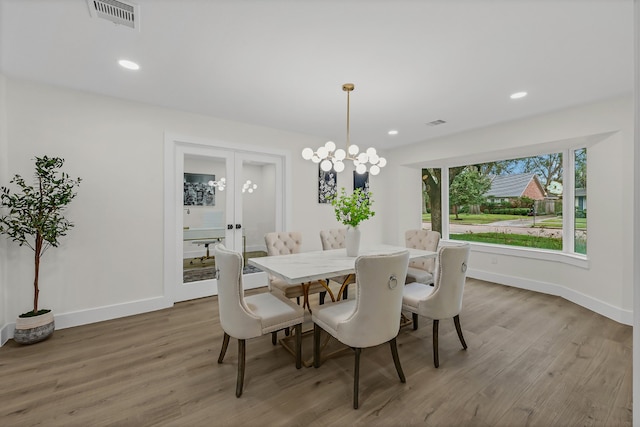 dining room with hardwood / wood-style floors and a chandelier