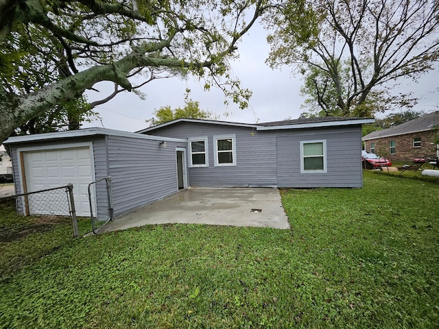 rear view of house with a garage and a yard